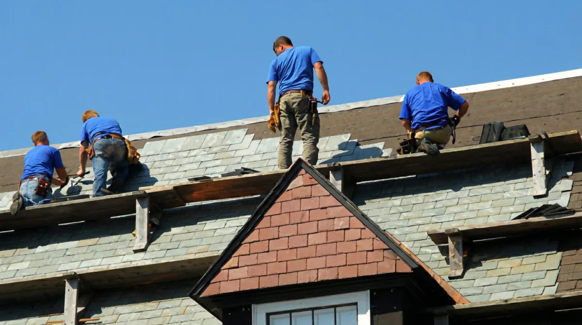 Roof replacement in progress with a team of professional contractors installing new shingles on a residential home in Overland Park, KS